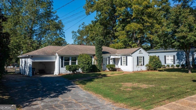 ranch-style house featuring an attached garage, a front lawn, and aphalt driveway