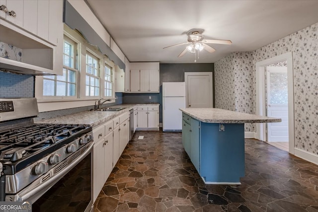 kitchen with a kitchen island, sink, appliances with stainless steel finishes, and white cabinets