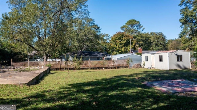 view of yard with fence and an outbuilding