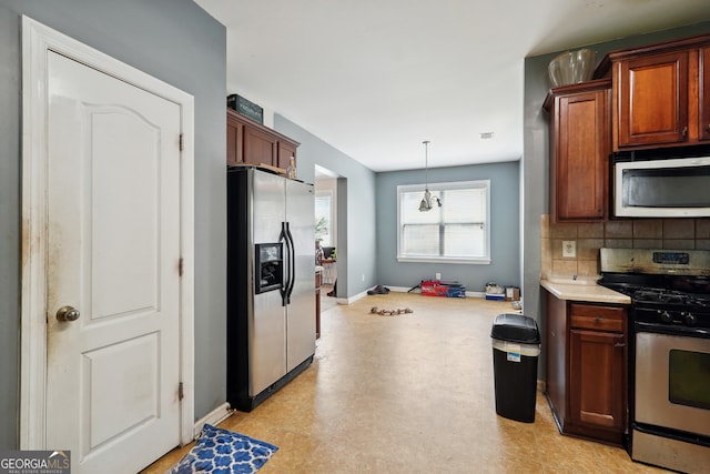 kitchen with stainless steel appliances, decorative backsplash, light tile patterned floors, and hanging light fixtures