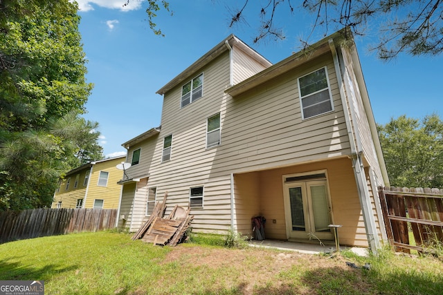 rear view of property featuring a lawn