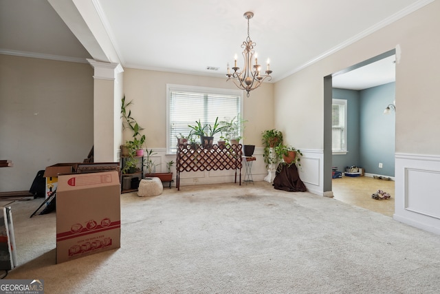 miscellaneous room with carpet, a chandelier, crown molding, and ornate columns