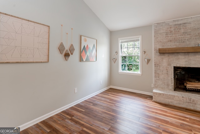 unfurnished living room with hardwood / wood-style floors, a fireplace, and vaulted ceiling