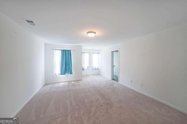 empty room with visible vents, baseboards, and carpet flooring