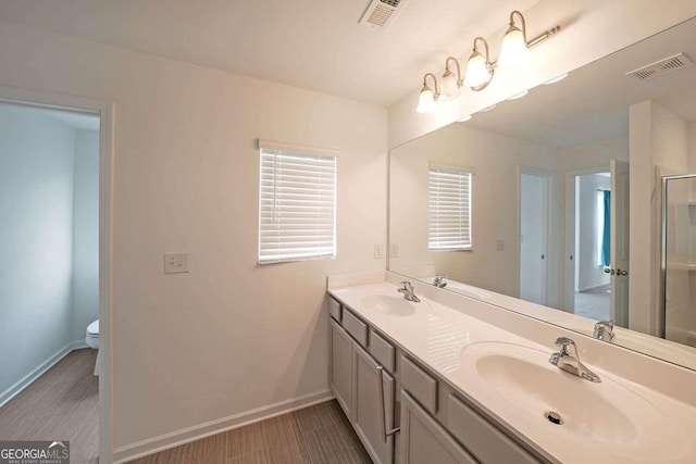 bathroom featuring double vanity, baseboards, visible vents, and a sink