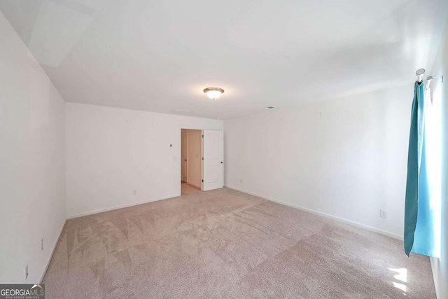 spare room with light carpet and baseboards