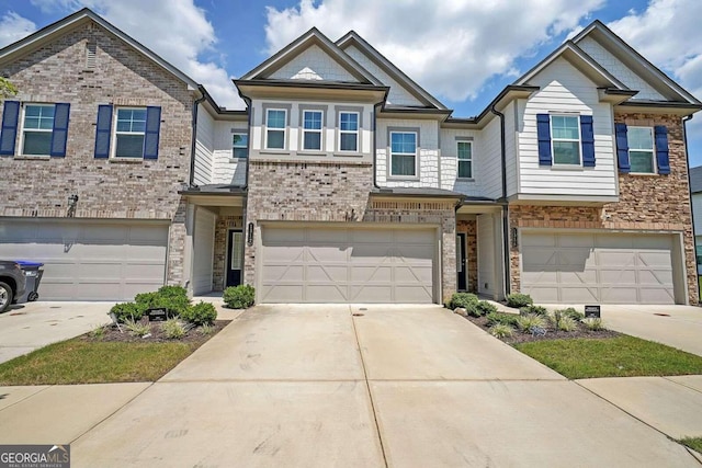 view of front of property with an attached garage, concrete driveway, and brick siding