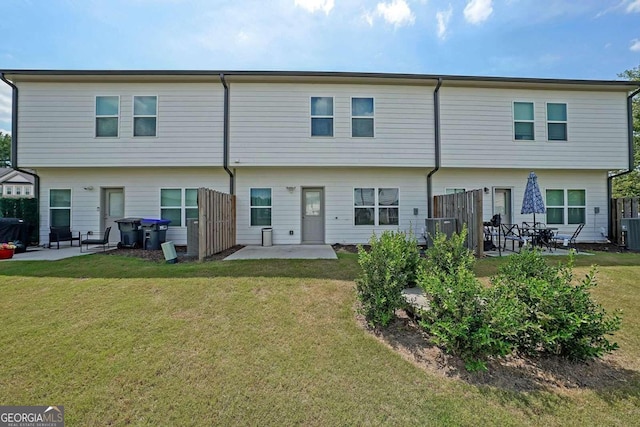 rear view of house with a patio area, a yard, central AC, and fence