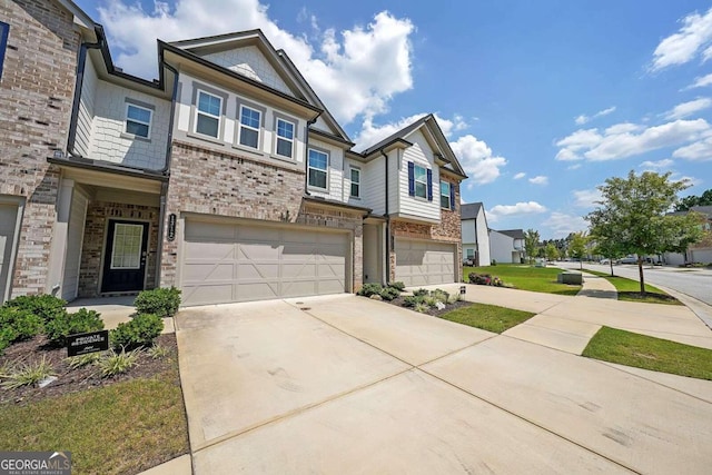 multi unit property featuring an attached garage, concrete driveway, and brick siding