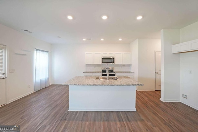 kitchen featuring decorative backsplash, appliances with stainless steel finishes, white cabinets, and dark wood-style flooring