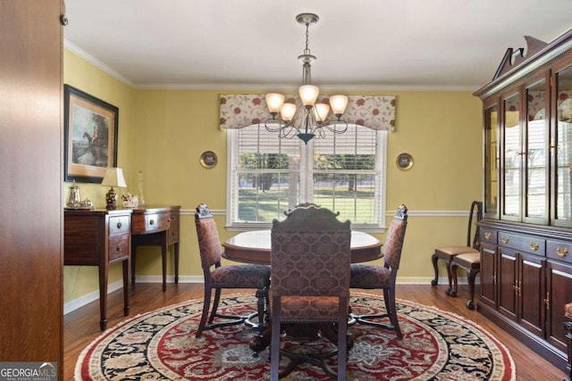 dining room with dark hardwood / wood-style floors, crown molding, and a notable chandelier