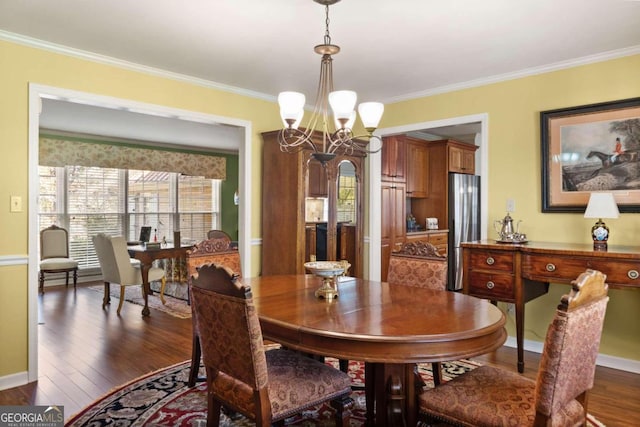 dining area featuring wood-type flooring, ornamental molding, and an inviting chandelier