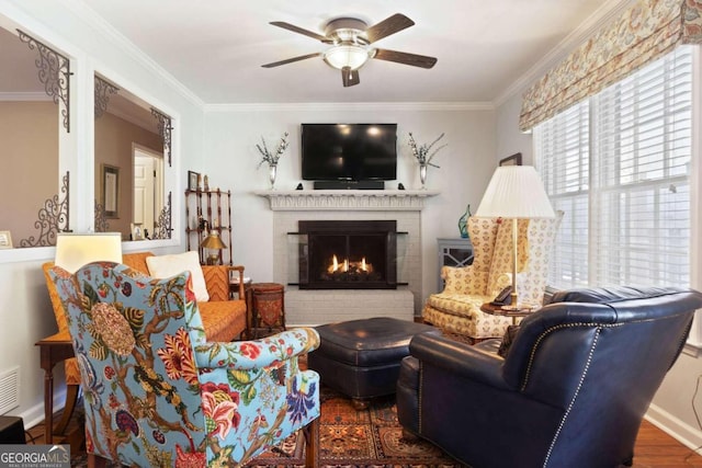 living room with ceiling fan, a brick fireplace, dark hardwood / wood-style floors, and ornamental molding