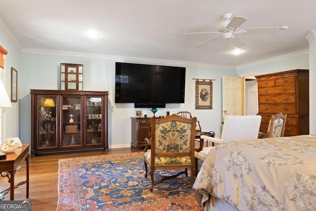 bedroom featuring ceiling fan, light hardwood / wood-style floors, and ornamental molding