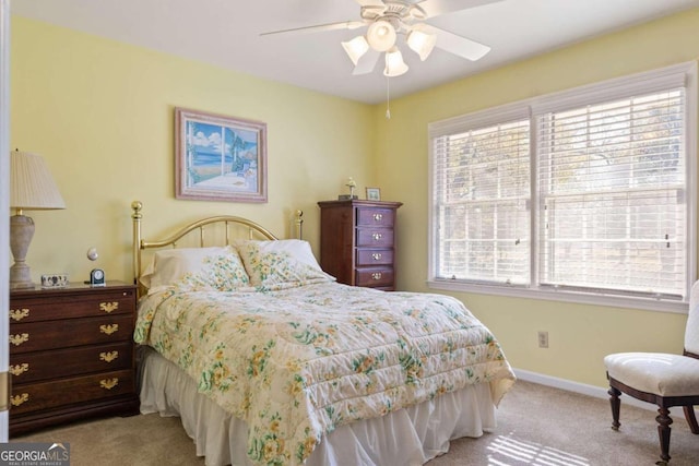 bedroom with ceiling fan, light carpet, and multiple windows