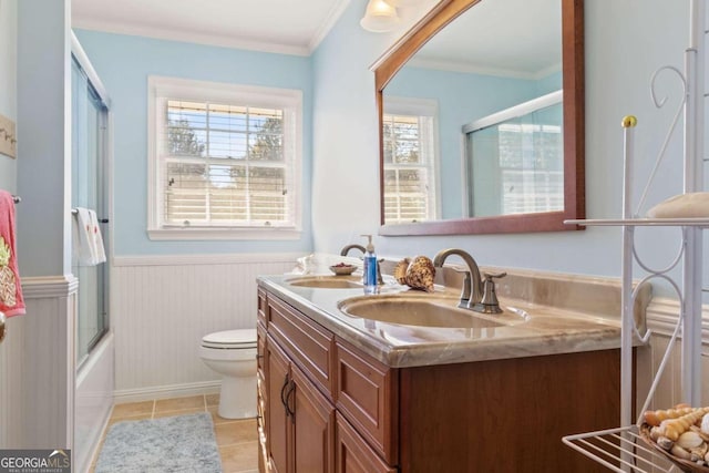 full bathroom with dual vanity, bath / shower combo with glass door, toilet, tile patterned flooring, and ornamental molding