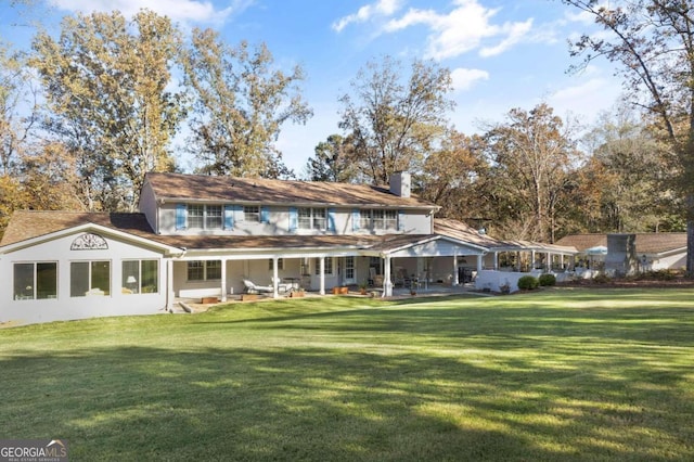 rear view of property featuring a lawn