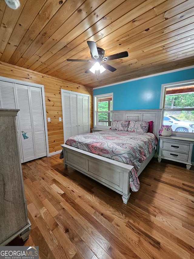 bedroom featuring light wood-type flooring, ceiling fan, wood ceiling, and wood walls