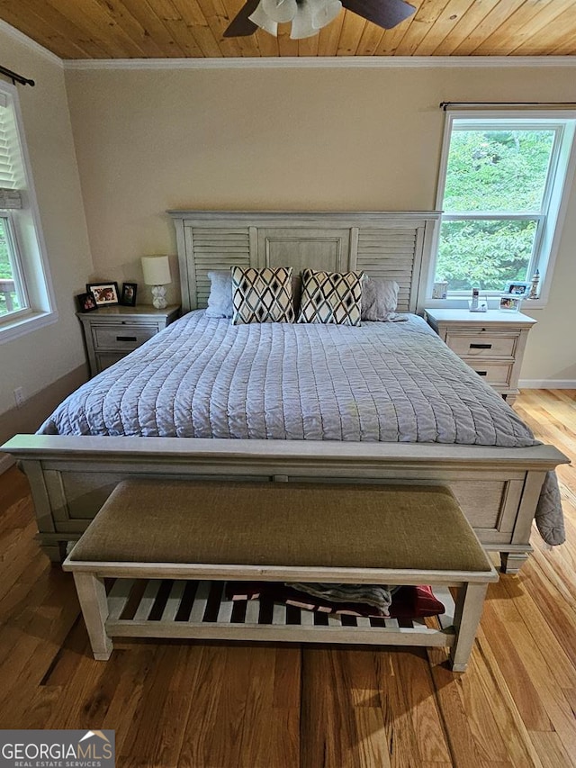 bedroom featuring ceiling fan, wooden ceiling, light hardwood / wood-style flooring, and crown molding