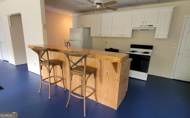 kitchen with electric stove, ceiling fan, a breakfast bar, fridge, and white cabinets