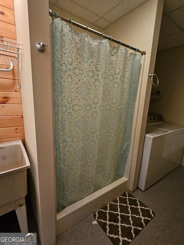 bathroom with a drop ceiling and washer / dryer