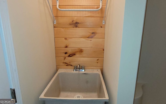 interior space featuring sink and wood walls