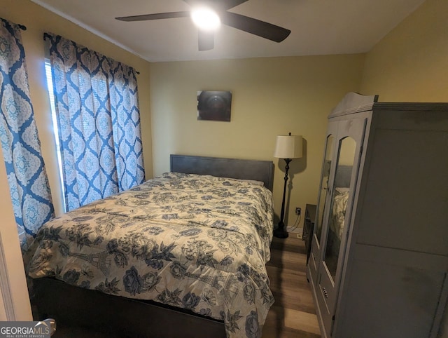 bedroom with dark wood-style flooring and a ceiling fan