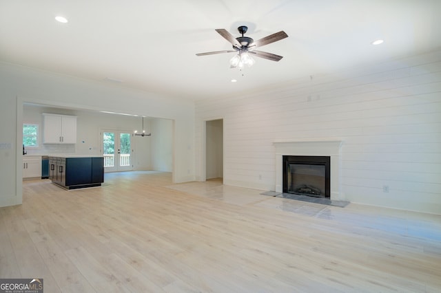 unfurnished living room featuring ceiling fan and light hardwood / wood-style floors