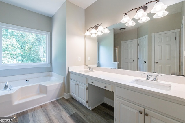 bathroom with vanity, a tub to relax in, hardwood / wood-style floors, and a chandelier