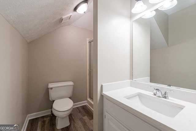 bathroom featuring vaulted ceiling, hardwood / wood-style floors, a shower with shower door, toilet, and a textured ceiling