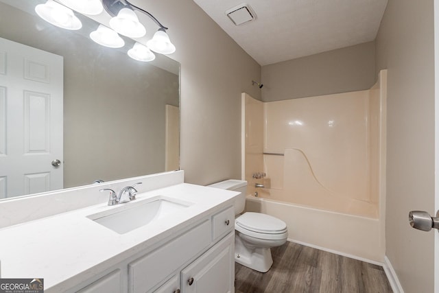 full bathroom with hardwood / wood-style flooring, shower / tub combination, vanity, and toilet