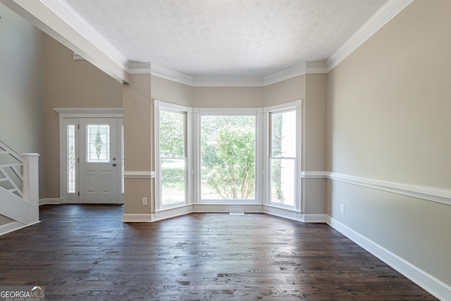 foyer entrance with dark hardwood / wood-style flooring, ornamental molding, and a textured ceiling