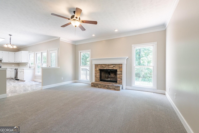 unfurnished living room featuring light carpet, a stone fireplace, ornamental molding, and a textured ceiling