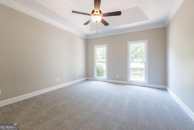 unfurnished room featuring a textured ceiling, ornamental molding, a tray ceiling, ceiling fan, and carpet