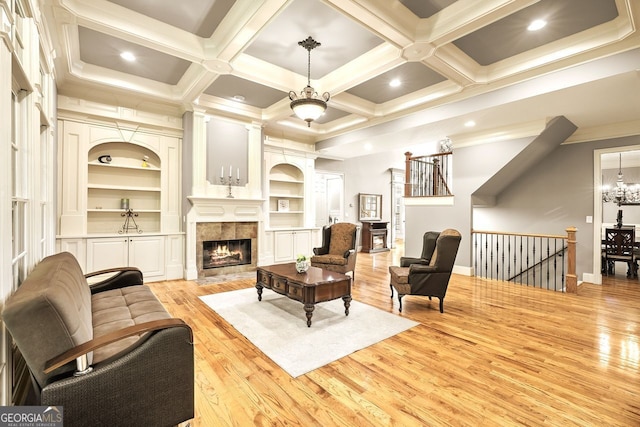 living room featuring beamed ceiling, light wood-type flooring, coffered ceiling, and a fireplace