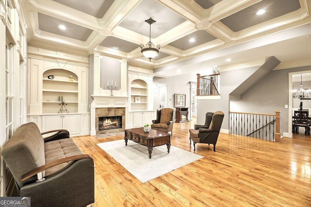 living room with light hardwood / wood-style flooring, beam ceiling, a tile fireplace, and coffered ceiling