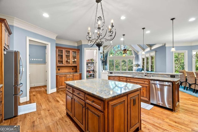 kitchen featuring pendant lighting, a wealth of natural light, stainless steel appliances, and a center island