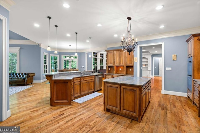 kitchen featuring stainless steel dishwasher, hanging light fixtures, and a large island with sink