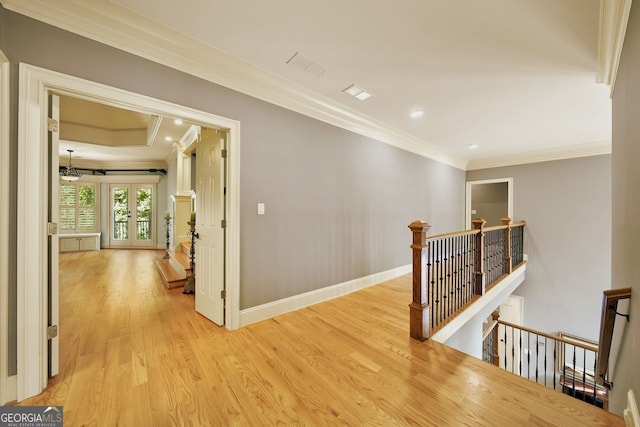 corridor with french doors, light wood-type flooring, and ornamental molding