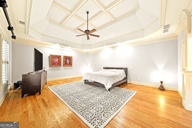 bedroom with ornamental molding, light wood-type flooring, ceiling fan, and a raised ceiling