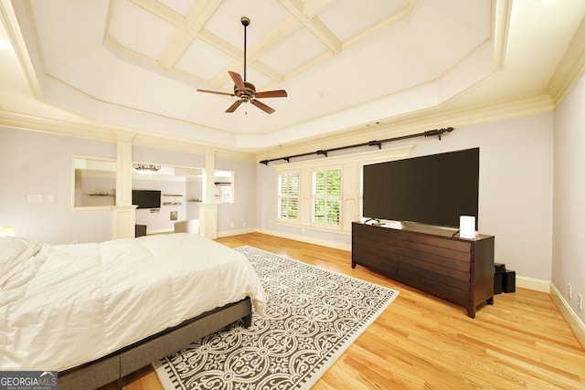 bedroom with wood-type flooring, coffered ceiling, ornamental molding, ceiling fan, and a raised ceiling