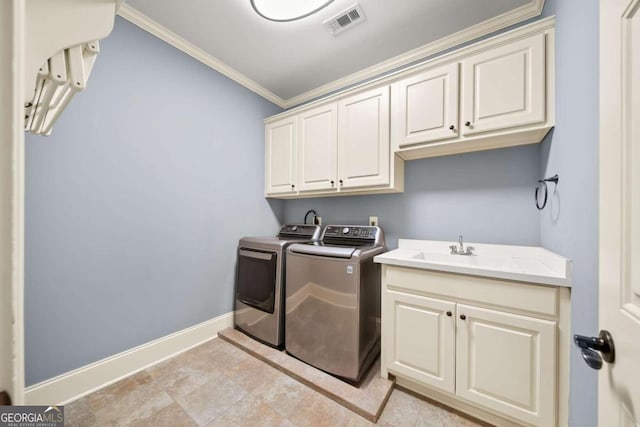 laundry room with cabinets, crown molding, sink, and washing machine and clothes dryer