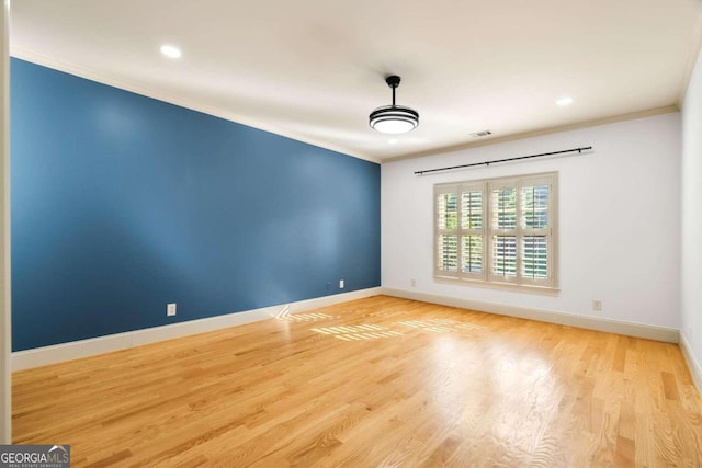 empty room with light wood-type flooring and crown molding