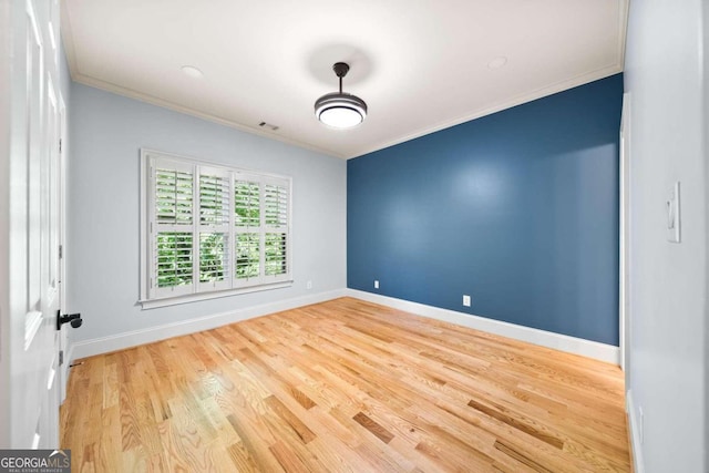 unfurnished room featuring wood-type flooring and crown molding