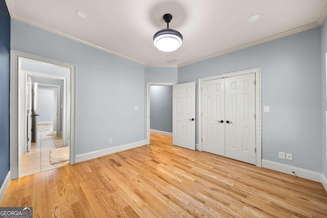 unfurnished bedroom featuring a closet, ornamental molding, and light hardwood / wood-style flooring