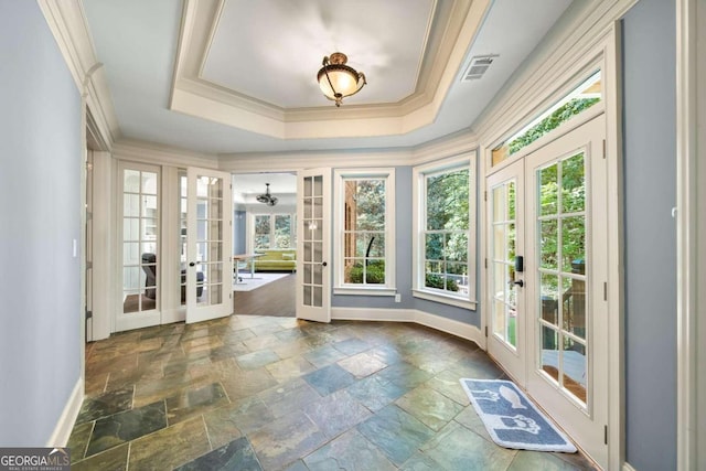 unfurnished sunroom featuring a healthy amount of sunlight, a raised ceiling, and french doors