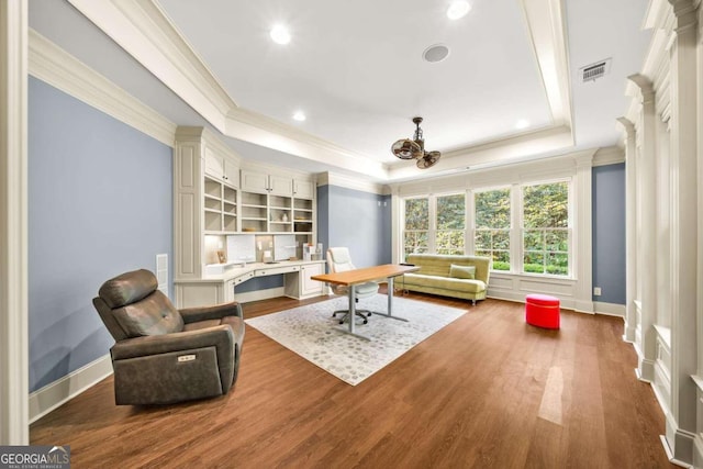 living area featuring a tray ceiling, hardwood / wood-style floors, and ornamental molding