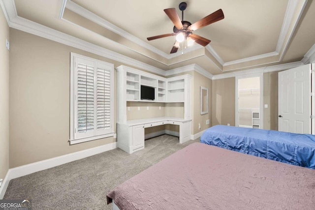 bedroom with light colored carpet, ceiling fan, crown molding, and a tray ceiling