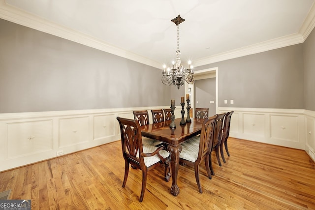 dining space featuring an inviting chandelier, light hardwood / wood-style floors, and crown molding