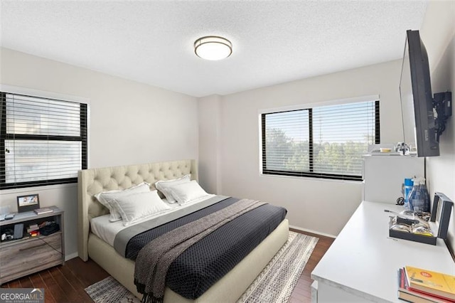 bedroom with dark hardwood / wood-style flooring and a textured ceiling